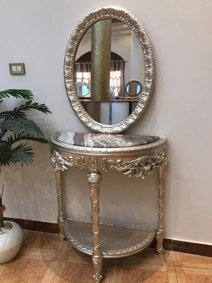 Silver baroque dining table base detail with teal tufted chairs